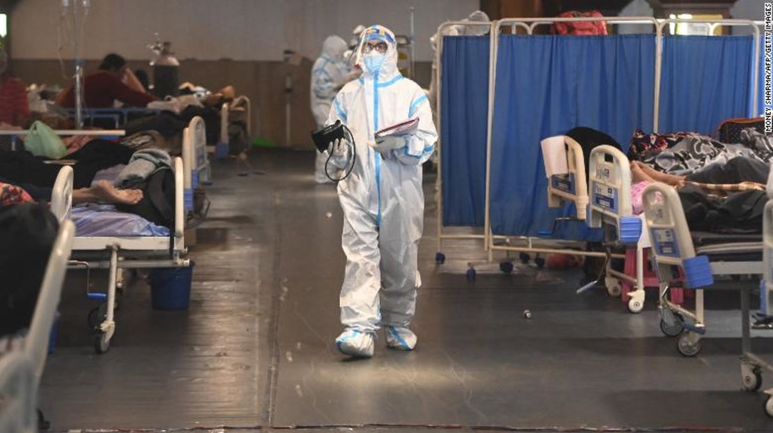 Un trabajador de la salud que usa un equipo de protección personal (EPP) camina dentro de un salón de banquetes convertido temporalmente en un pabellón Covid-19 en Nueva Delhi.