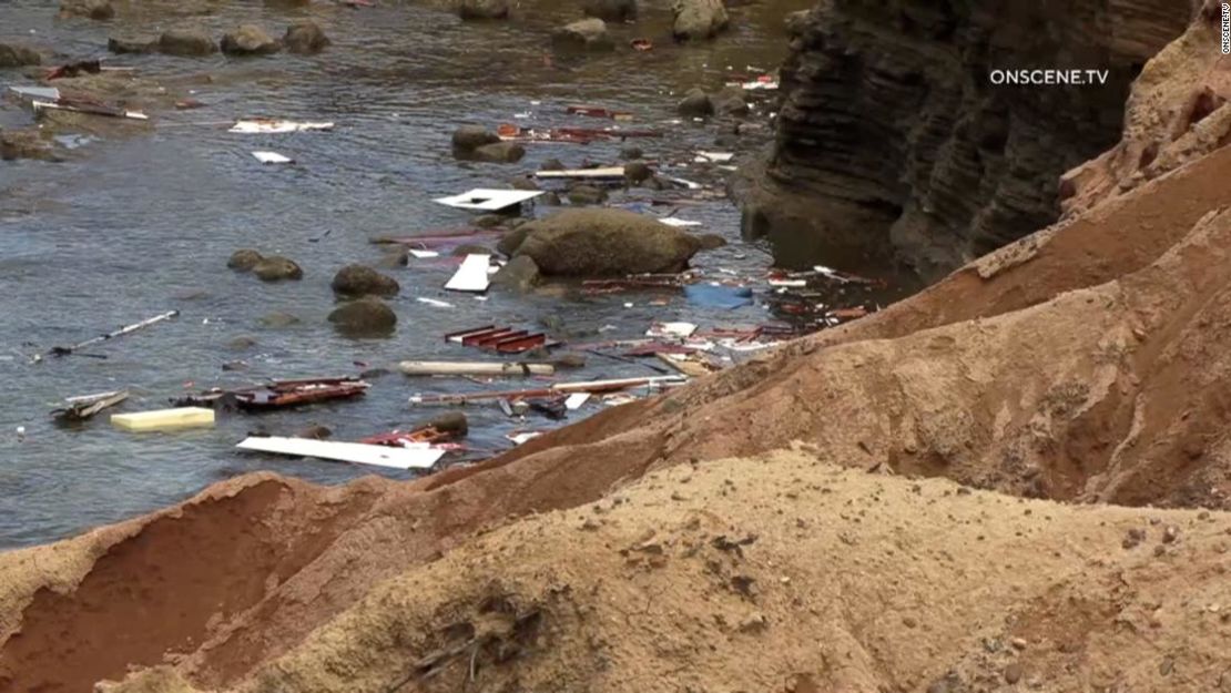 Los restos del bote volcado se ven cerca de la orilla.