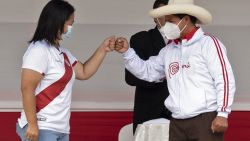 Peruvian presidential candidates, leftist Pedro Castillo (R) and right-wing Keiko Fujimori shake their clenched fists ahead of a debate in Chota, Cajamarca,northern Peru on May 1, 2021, ahead of the June 6 presidential runoff election, which threatens to polarize the country. - The candidates addressed issues of health, education, security, economy and corruption in debate that arose after a challenge from Fujimori to her rival. (Photo by Cesar BAZAN / AFP)