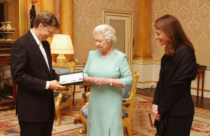 La reina Isabel II entrega a Bill Gates su título de caballero honorario en un evento al que asistió con Melinda el 2 de marzo de 2005 en el Palacio de Buckingham en Londres, Inglaterra.