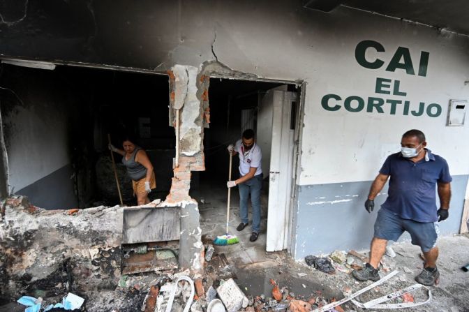 Un grupo de personas limpian una estación de policía quemada en la noche del 4 de mayo en Cali, en el suroccidente de Colombia, en el marco de las manifestaciones antigubernamentales.