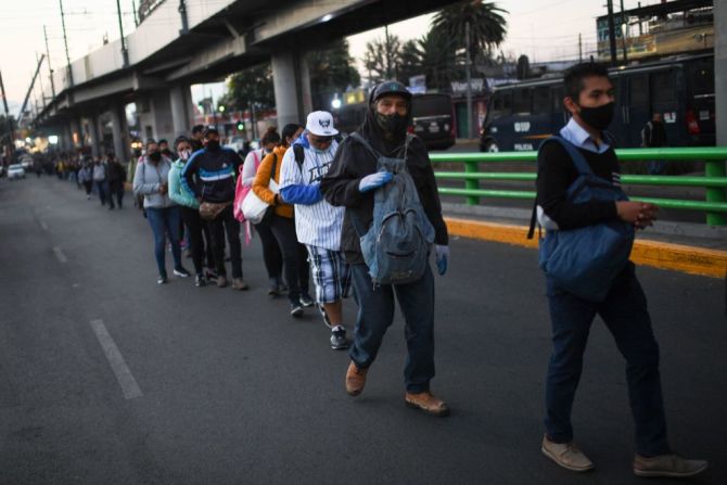 Pasajeros hacen cola en busca de transporte en el área del accidente del metro elevado de Ciudad de México.