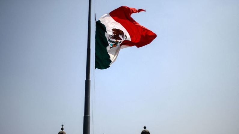 La bandera mexicana ondea a media asta en la Plaza Zócalo en la Ciudad de México el 5 de mayo de 2021, después de que al menos 25 personas murieron en el accidente del metro elevado.