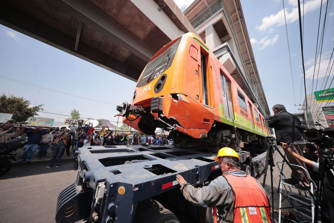 Un tráiler se lleva uno de los vagones del tren tras el derrumbe.