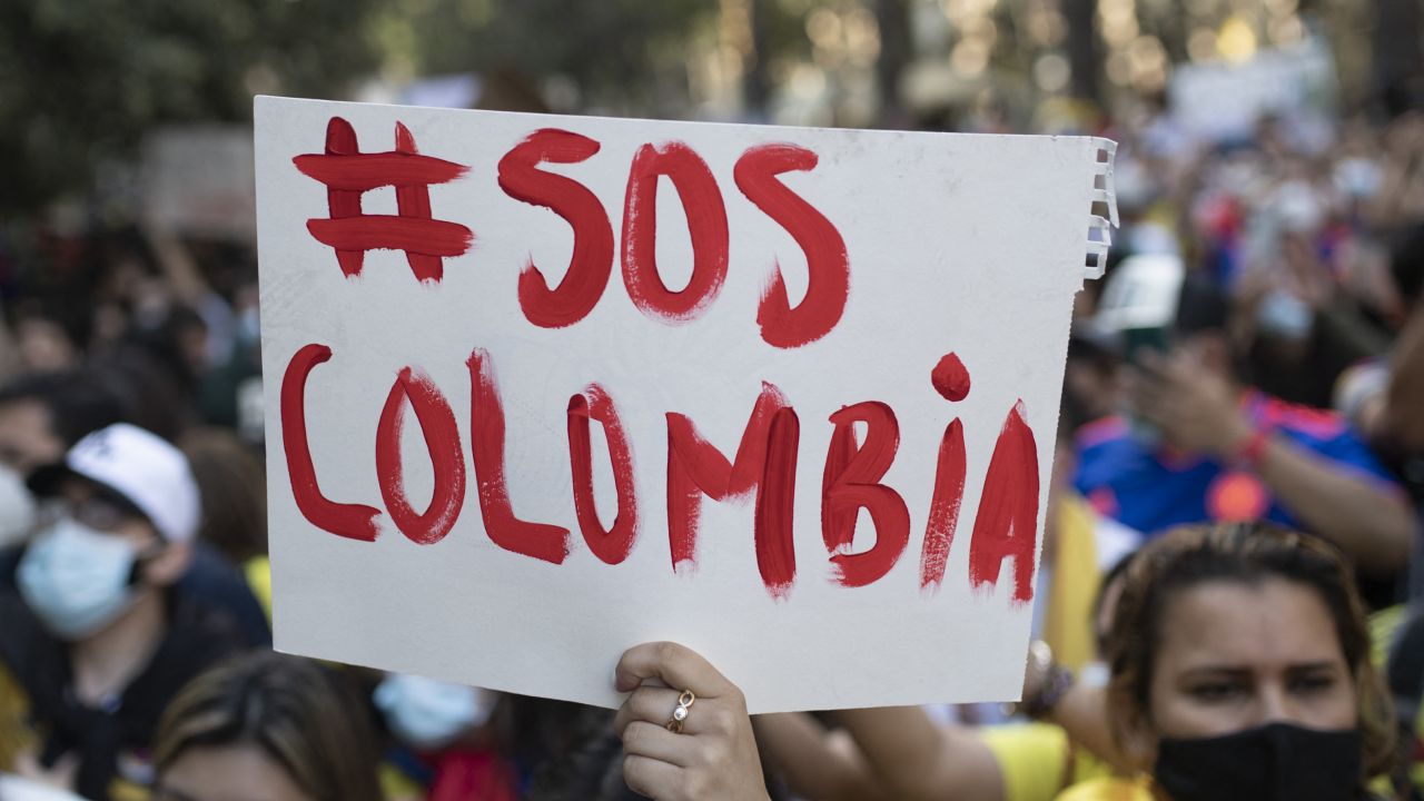 A Colombian citizen holds a placard reading "SOS Colombia" during a demonstration against President Ivan Duque's government in Barcelona, on May 5, 2021. - Colombia braced for a new day of protests against President Ivan Duque following a week of deadly clashes between demonstrators and security forces that brought international condemnation. (Photo by Josep LAGO / AFP)
