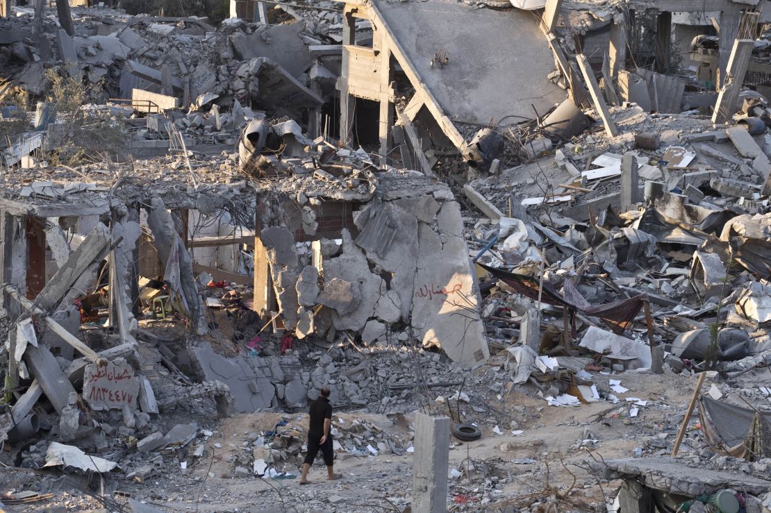 Un palestino camina entre edificios destruidos durante los combates entre militantes de Hamas e Israel en el barrio de Al-Shaas, en el norte de Gaza, el 16 de agosto de 2014. Crédito: ROBERTO SCHMIDT/AFP/Getty Images