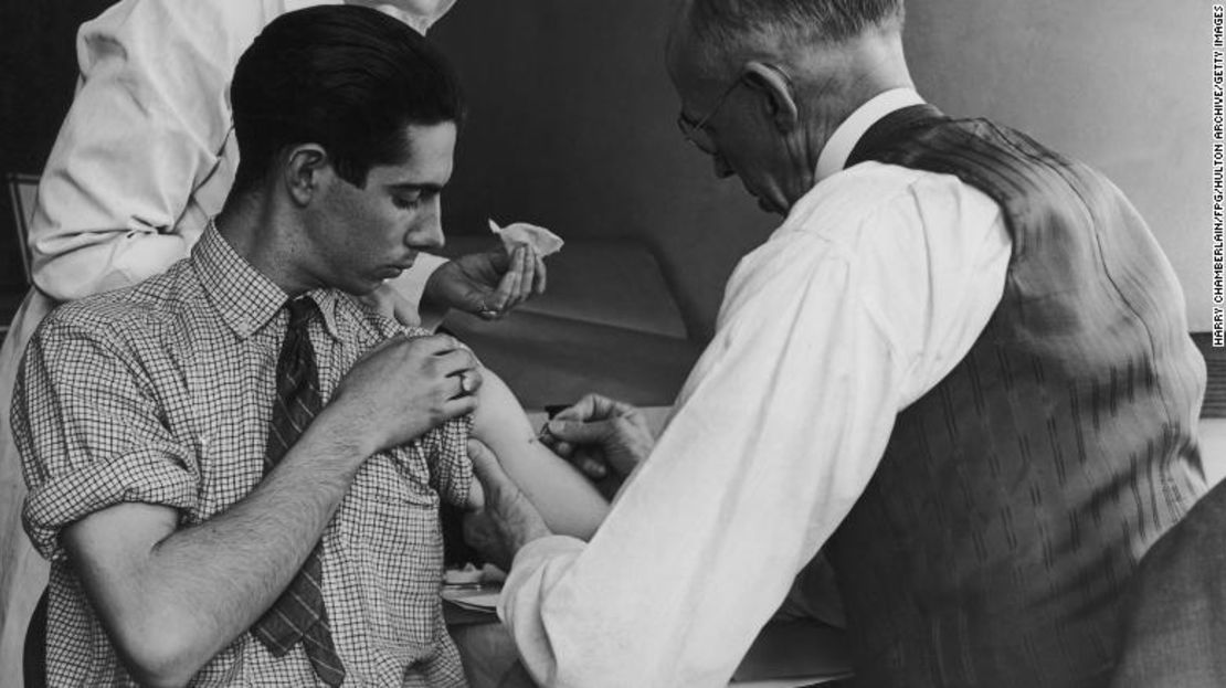 Un médico y una enfermera de la escuela administraron una vacuna contra la viruela en 1938 a un adolescente en Gasport, Nueva York.