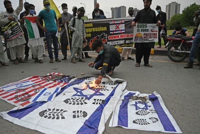 Un manifestante enciende banderas israelíes y estadounidenses durante una protesta celebrada en Islamabad, Pakistán, el 12 de mayo de 2021 para protestar contra los mortíferos ataques aéreos de Israel lanzados en Gaza que matado decenas de personas.