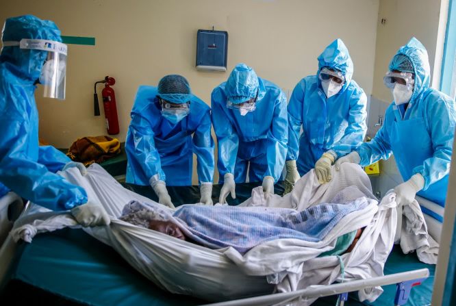 Un equipo médico traslada a un paciente con covid-19 de una cama a una camilla en un hospital, en Nairobi, Kenya, el 14 de abril.