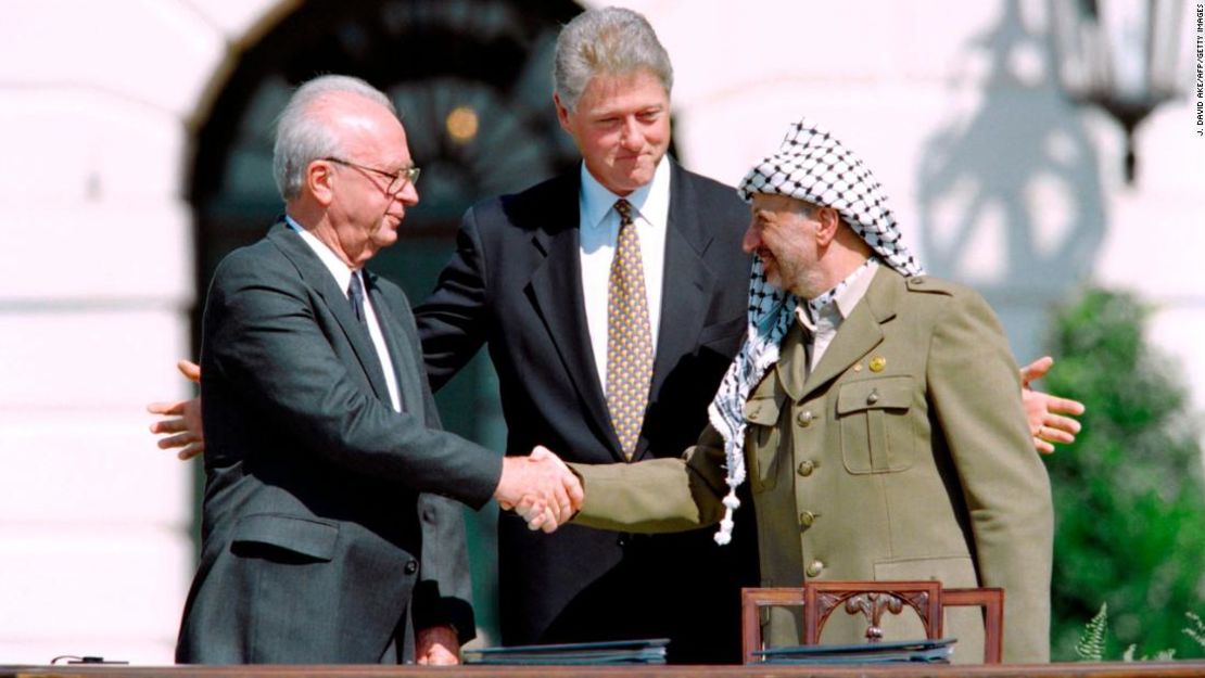 El entonces presidente de Estados Unidos, Bill Clinton, observa cómo el primer ministro de Israel, Yitzhak Rabin, a la izquierda, y el líder de la OLP, Yasser Arafat, se dan la mano el 13 de septiembre de 1993 en la Casa Blanca tras la firma de los Acuerdos de Oslo.