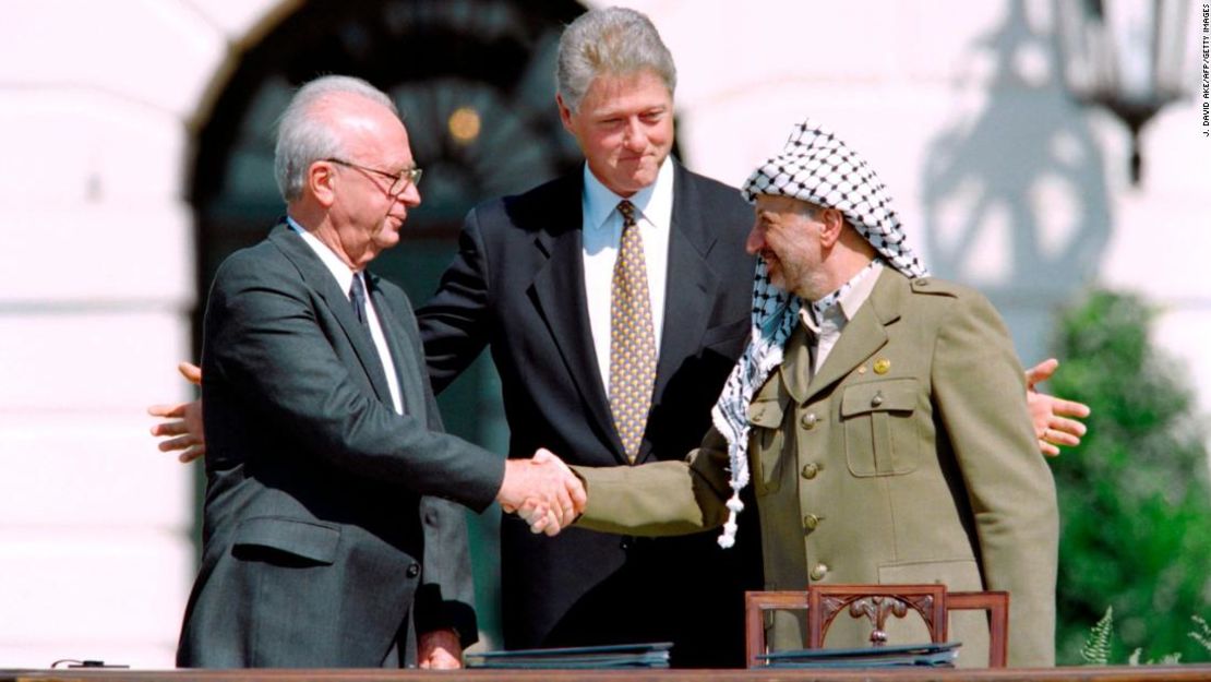 El entonces presidente de Estados Unidos, Bill Clinton, observa cómo el primer ministro de Israel, Isaac Rabin, a la izquierda, y el líder de la OLP, Yasser Arafat, se dan la mano el 13 de septiembre de 1993 en la Casa Blanca tras la firma de los Acuerdos de Oslo.
