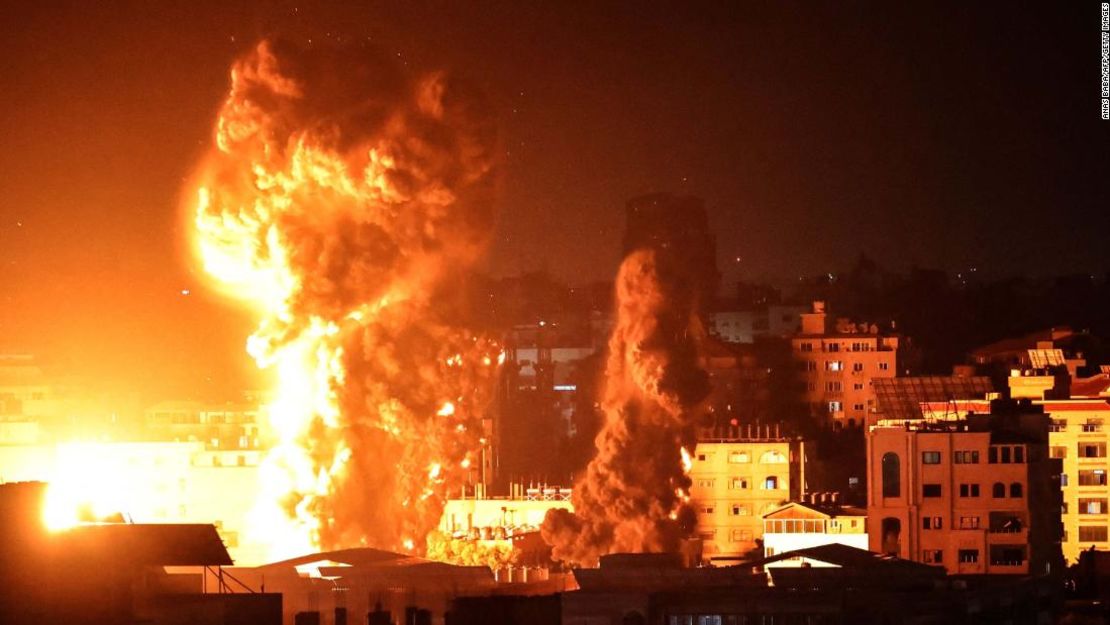 El humo se eleva por encima de los edificios en la ciudad de Gaza mientras aviones de combate israelíes apuntan a los enclaves palestinos la madrugada del lunes.