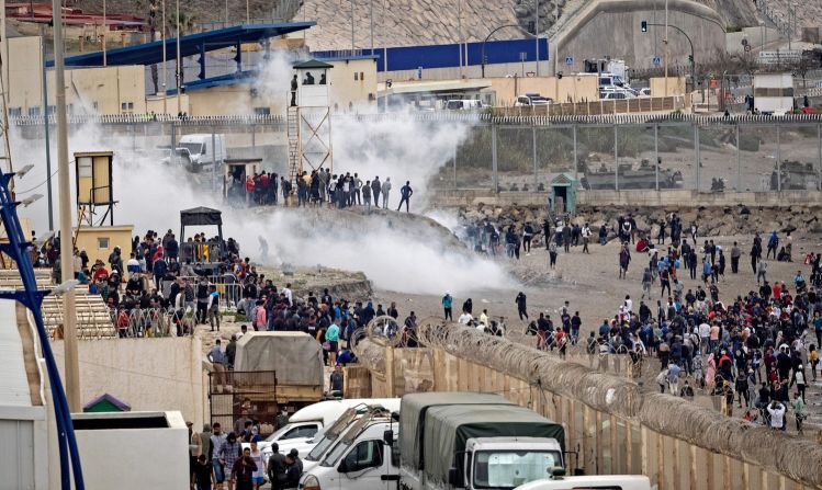 La policía lanzó gases lacrimógenos a migrantes marroquíes en el borde de la reja en el norte de la ciudad de Fnideq en un intento por cruzar desde Marruecos hasta Ceuta, el énclave español en el norte de África. FADEL SENNA/AFP via Getty Images)