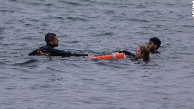 Un agente de la Guardia Civil rescata del agua a los inmigrantes que llegaron a territorio español cerca de la frontera con Marruecos en el énclave español de Ceuta.