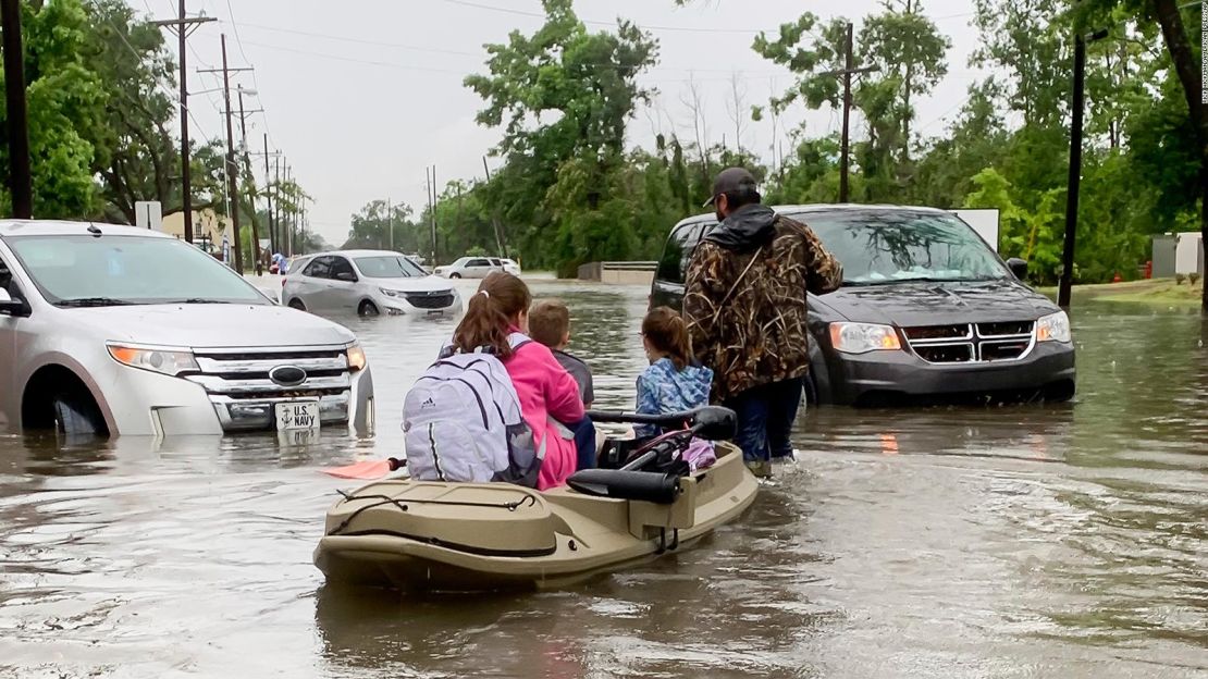 Padres usan un bote para recoger a sus hijos en la escuela luego de las lluvias torrenciales que cayeron en Lake Charles, Louisiana.