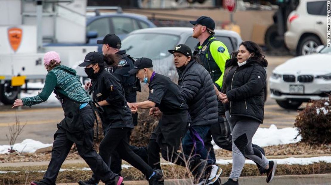 Agentes de seguridad escoltan a personas fuera de la tienda de comestibles King Soopers en el sur de Boulder, Colorado.