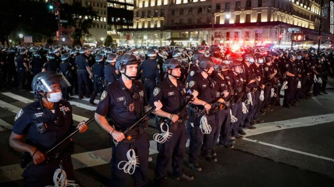 Agentes de la Policía de Nueva York formados después de arrestar a múltiples manifestantes cuando pasó el toque de queda.