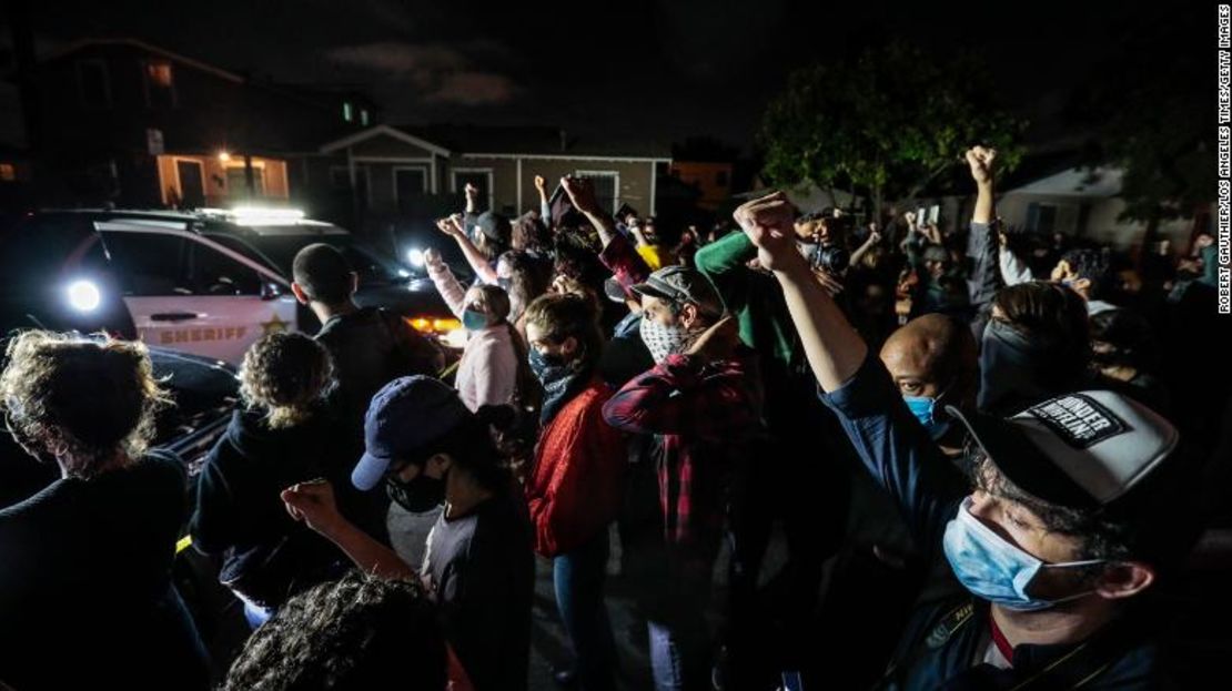 Manifestantes reunidos frente a agentes del sheriff del condado de Los Ángeles el lunes en la noche.