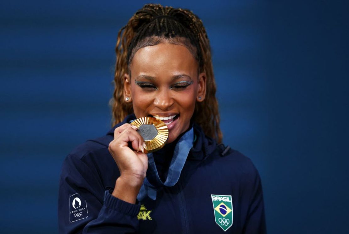 La medallista de oro Rebeca Andrade del equipo de Brasil muerde su medalla después de la ceremonia de entrega de medallas de ejercicio de piso femenino de gimnasia artística el décimo día de los Juegos Olímpicos París 2024 en Bercy Arena el 5 de agosto de 2024 en París, Francia.