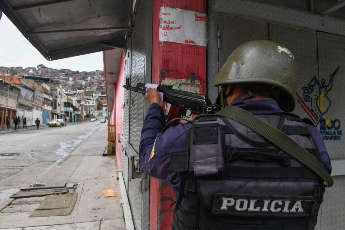 Un miembro de la Policía Nacional Bolivariana apunta a un posible objetivo luego de enfrentamientos con presuntos miembros de una banda criminal en el barrio Cota 905, en Caracas, el 9 de julio de 2021. - Fuerzas de seguridad venezolanas ingresaron el viernes a cuatro barrios pobres de la capital Caracas buscando Para poner fin a días de enfrentamientos con bandas armadas que se han cobrado varias vidas.