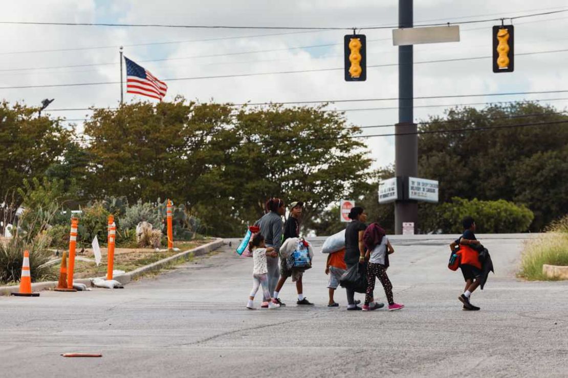 Un grupo de inmigrantes camina desde el Centro de Recursos al Inmigrante hacia un centro comercial en busca de comida, el 19 de septiembre de 2022 en San Antonio, Texas