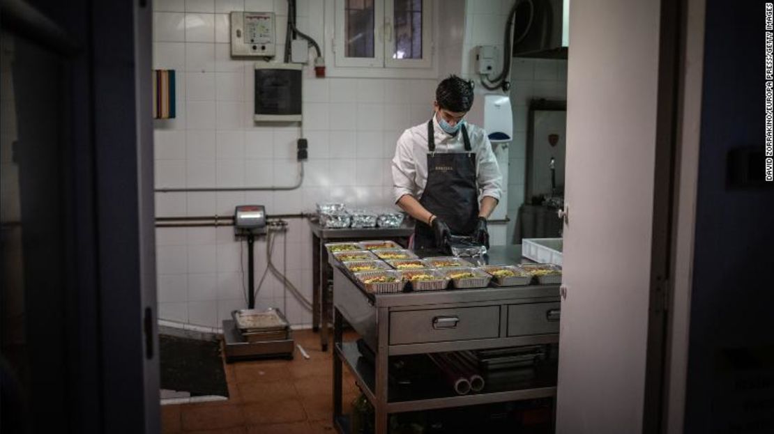 Un cocinero trabaja en un restaurante de Barcelona que prepara comida para el personal sanitario y personas vulnerables.