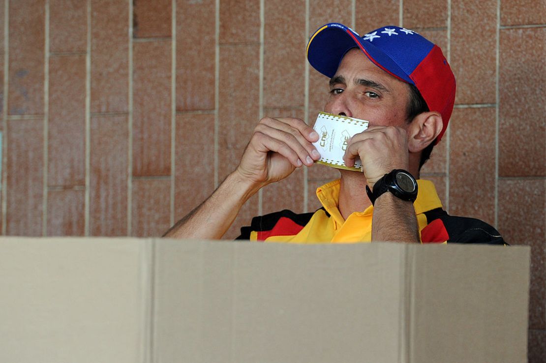 El entonces gobernador del estado de Miranda y líder de la oposición, Henrique Capriles Radonski, besa su voto durante las elecciones municipales en un colegio electoral en Caracas el 8 de diciembre de 2013. Crédito: Pedro GUZMAN/AFP vía Getty Images