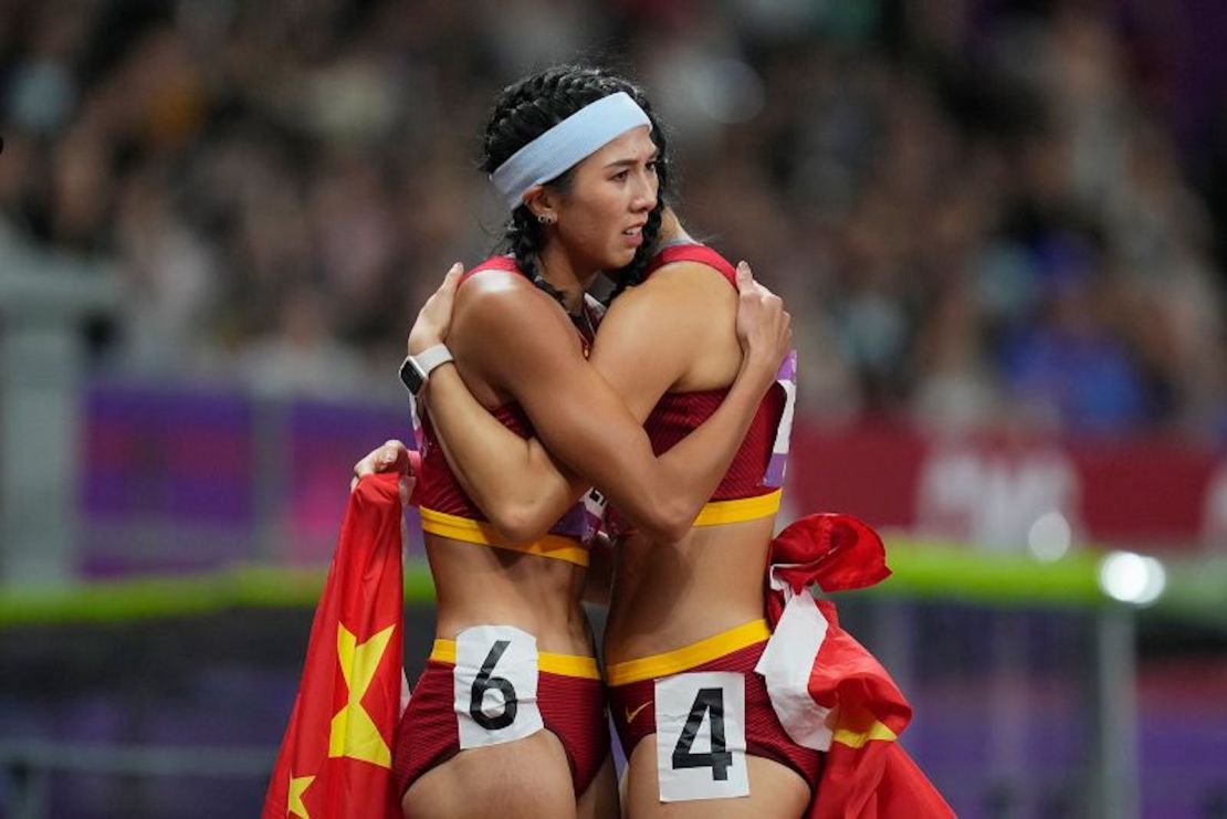 La medallista de oro china Lin Yuwei, a la izquierda, abraza a su compañera de equipo Wu Yanni tras su final femenina de 100 metros vallas en los XIX Juegos Asiáticos de Hangzhou, China, el 1 de octubre de 2023.