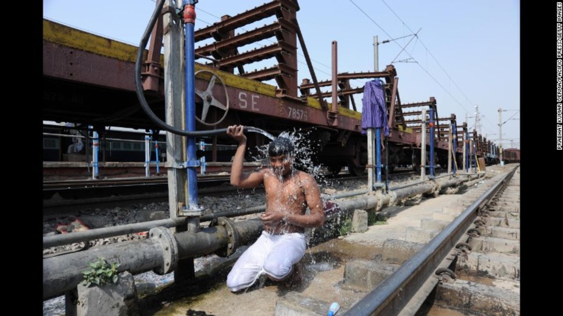 Un hombre se refresca junto a la vía del tren en Allahabad, India. Ese país está siendo castigado por una intensa ola de calor.