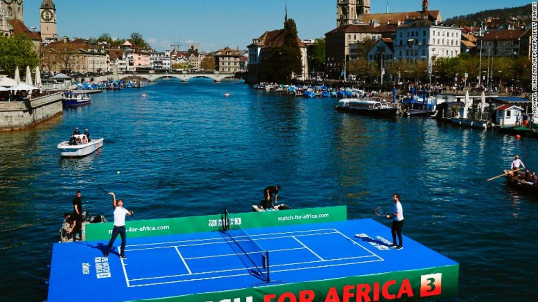 Roger Federer (i) pelotea junto al número uno del mundo, Andy Murray, en una cancha de tenis flotante durante el Match for Africa 3 para recaudar fondos para la fundación del suizo.