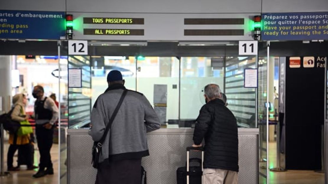 Viajeros muestran sus documentos a un agente de la policía fronteriza en el mostrador de inmigración del aeropuerto internacional Charles-de-Gaulle, el 1 de febrero de 2021. Christophe Archambault/AFP/Getty Images