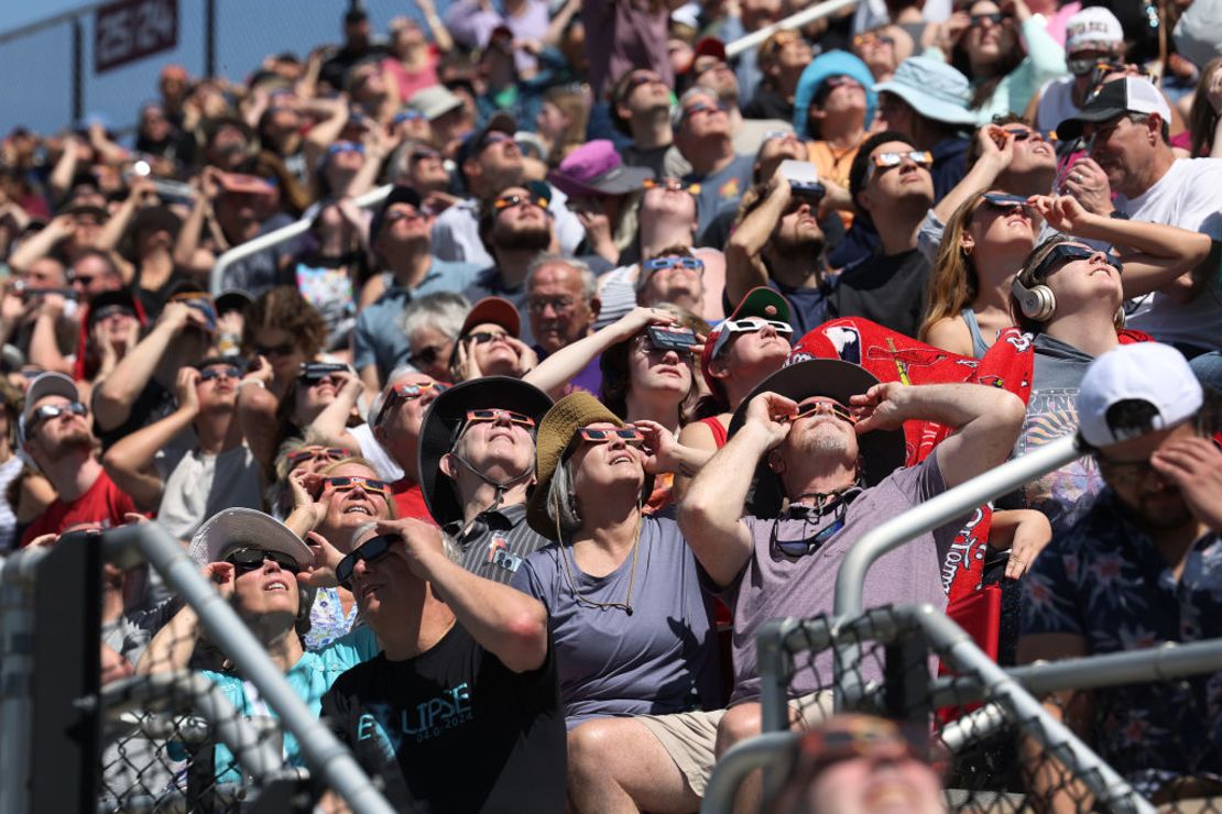 La gente ve el comienzo del eclipse solar total en el campus de la Universidad del Sur de Illinois el 8 de abril 2024 en Carbondale, Illinois.