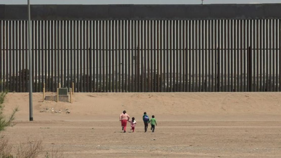 Una mujer y tres niños pequeños corren hacia el muro en la frontera entre Estados Unidos y México en Ciudad Juárez, México. Fueron detenidos por la Patrulla Fronteriza de Estados Unidos unos minutos después.