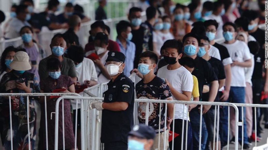 Gente que tuvo contacto con el mercado Xinfadi en fila para hacerse la prueba de coronavirus el 17 de junio.