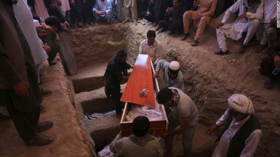 Afganos cargan el cuerpo de una víctima de la masacre en una boda en un funeral masivo en Kabul.