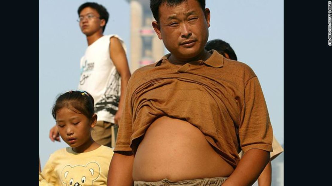 Residentes afuera mientras la temperatura sube en Shangai, el 4 de agosto de 2005.