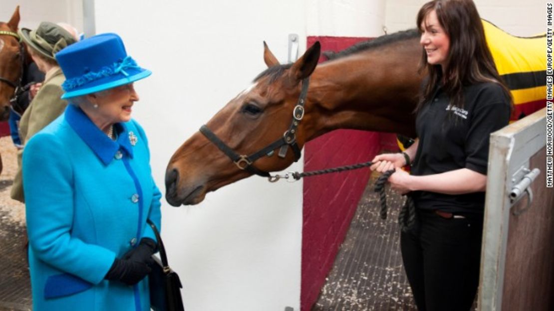 Una sonriente reina Isabel II, conocida por su amor por los caballos, llama la atención de este equino.