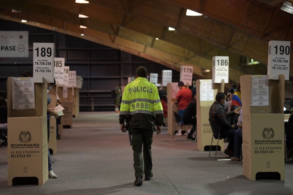 Un policía vigila un colegio electoral durante las elecciones parlamentarias en Bogotá, el 13 de marzo de 2022. Los policías en servicio son parte de la población que no puede votar en los comicios.