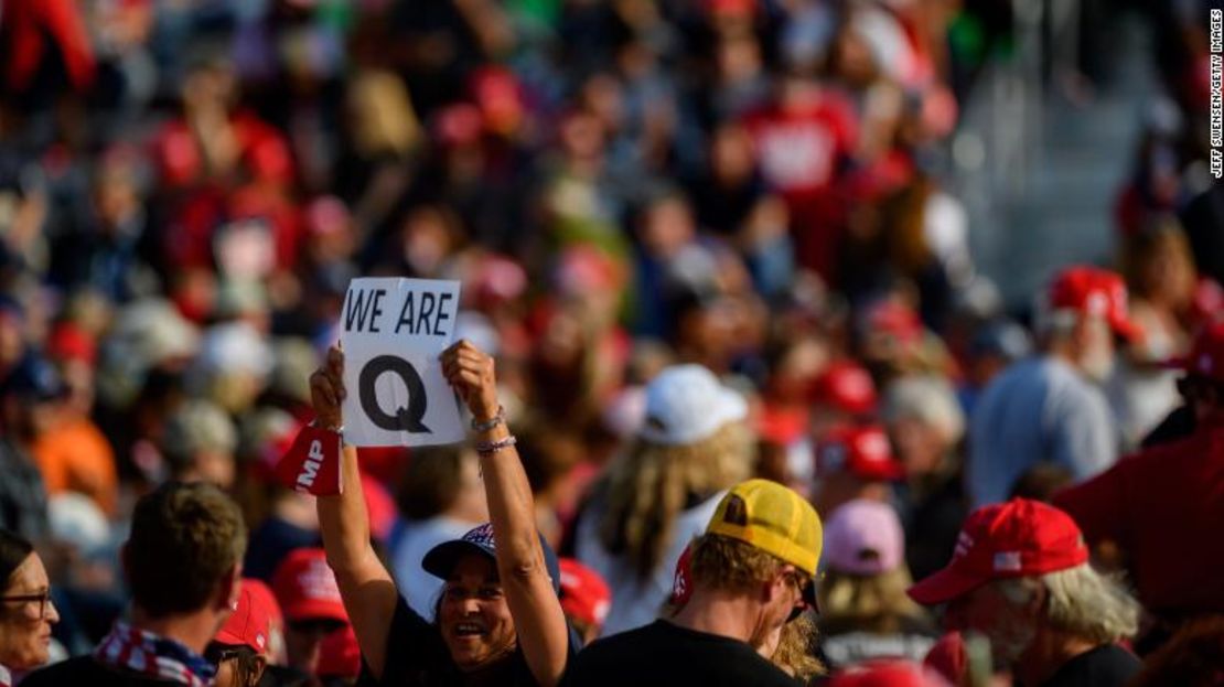 Una mujer sostiene un signo de QAnon a los medios mientras los asistentes esperan que Donald Trump hable en un mitin de campaña en Moon Township, Pensilvania, el 22 de septiembre.