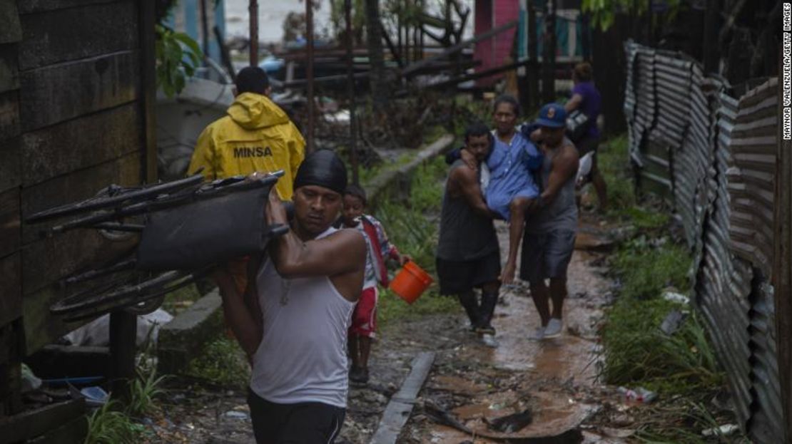 Pobladores cargan a una mujer durante una evacuación antes de que el huracán Iota toque tierra el 16 de noviembre de 2020 en Puerto Cabezas, Nicaragua.