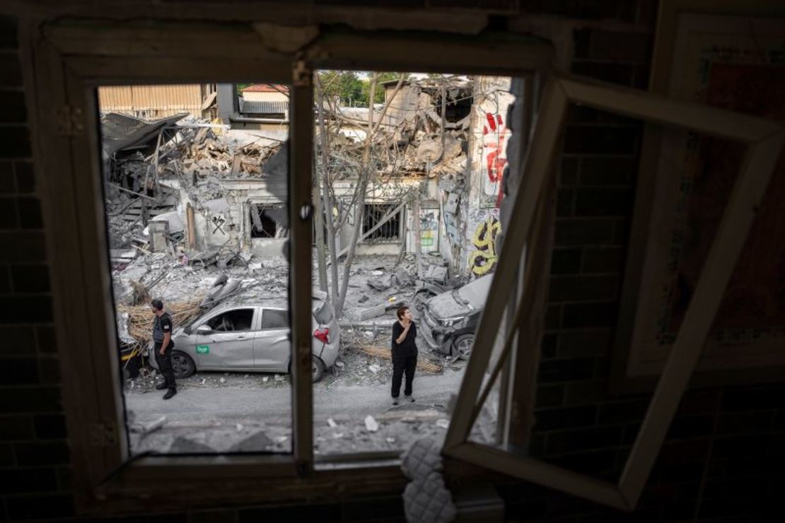 Israelíes inspeccionan los escombros de un edificio un día después de que fuera alcanzado por un cohete disparado desde la Franja de Gaza, en Tel Aviv, Israel, este domingo.