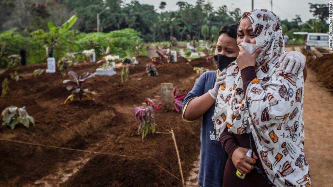 Una mujer hace duelo con su hijo en el funeral de su madre en el cementerio Mulyaharja para víctimas del coronavirus en Bogor, Java occidental, el 8 de julio.