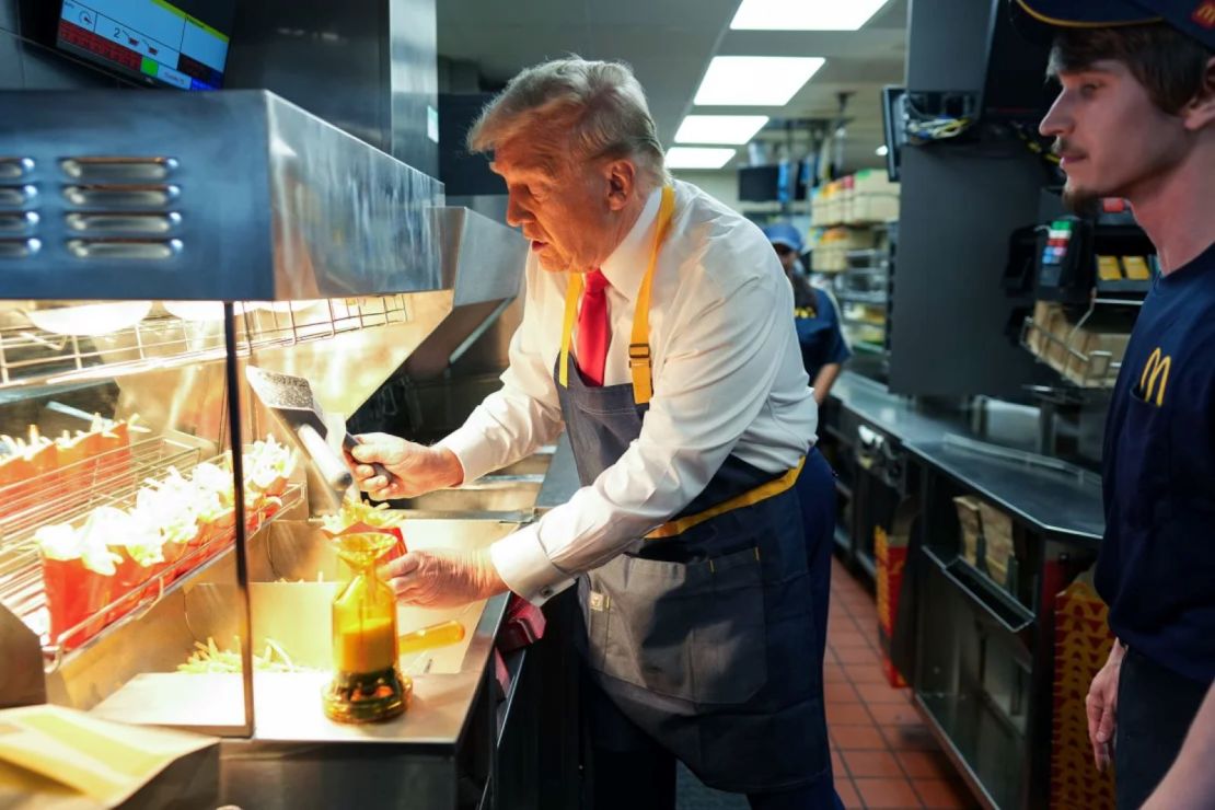 Trump trabaja detrás del mostrador preparando papas fritas durante una visita a un restaurante de McDonald's el 20 de octubre de 2024 en Feasterville-Trevose, Pensilvania.