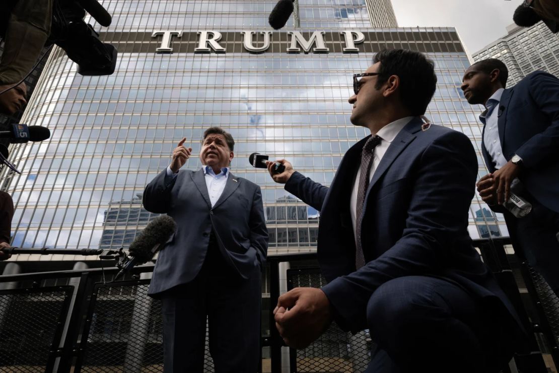 El gobernador de Illinois, JB Pritzker, habla con la prensa mientras está a bordo de un taxi acuático pasando por la Torre Trump en el río Chicago este lunes.