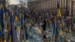 Visitantes se acercan a un memorial improvisado en homenaje a combatientes ucranianos y extranjeros en la Plaza de la Independencia de Kyiv, antes del tercer aniversario de la invasión de Ucrania por parte de Rusia.