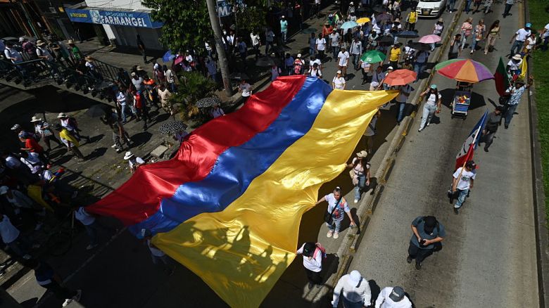Personas portan una enorme bandera colombiana durante una marcha a favor de las reformas propuestas por el presidente de Colombia, Gustavo Petro, durante una huelga convocada por los sindicatos en Cali, Valle del Cauca, Colombia, el 28 de mayo de 2025.