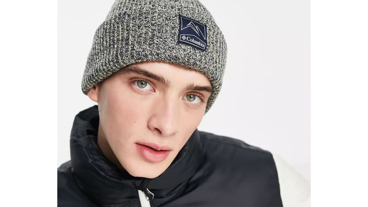 Man wearing beige/navy heather Columbia Whirlibird beanie