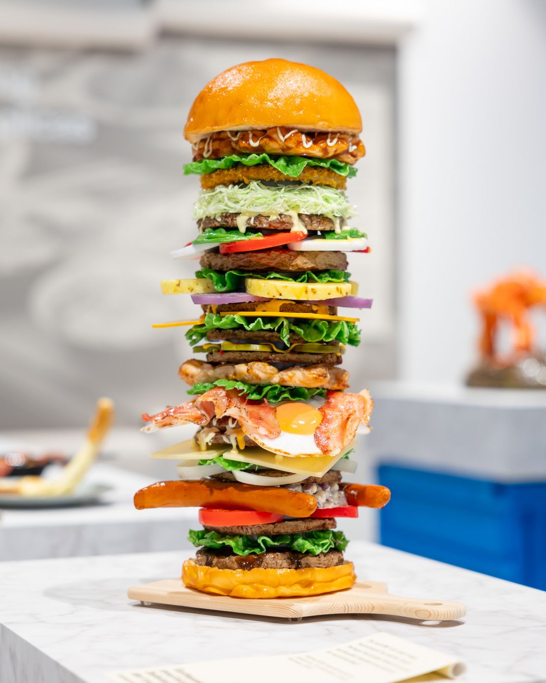 A food replica of a towering burger stacked, produced for one of the Iwasaki Group's internal competitions between its employees.