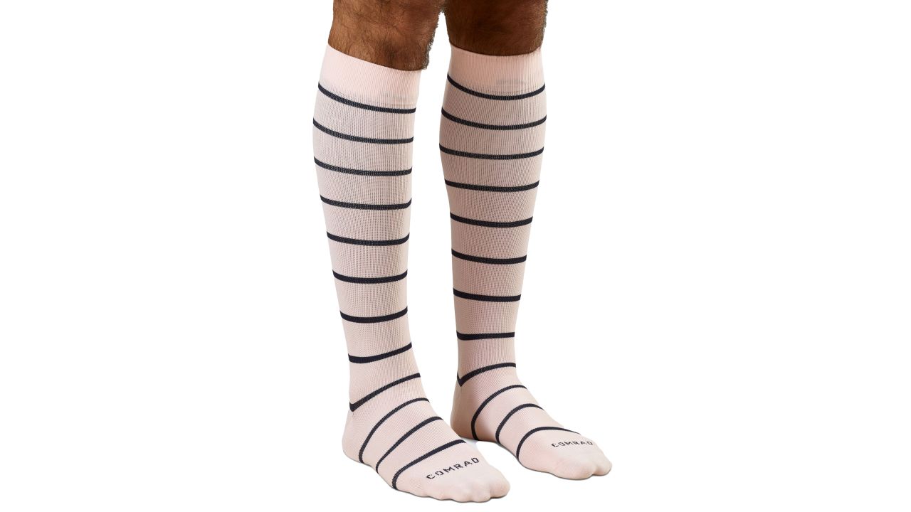 Person wearing knee-high Comrad compression socks in rose/navy stripes