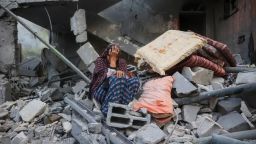 Una mujer palestina sentada sobre los escombros de su casa, destruida por un ataque israelí, en el campo de refugiados de Nuseirat, en el centro de Gaza, este martes.